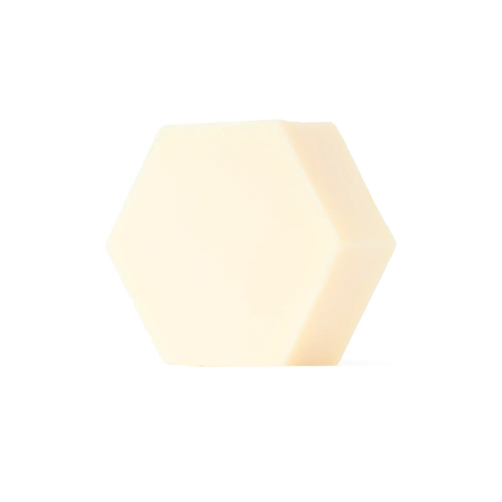 Luonkos Hydrate Essence Hand & Body Soap von Luonkos ist ein heller, cremefarbener, sechseckiger Seifenblock mit natürlichen Pflanzenölen - ideal als parfümfreie Körperseife für empfindliche Haut, dargestellt auf einem schlichten weißen Hintergrund.