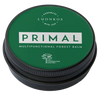 Eine grüne, runde Luonkos-Dose mit der Aufschrift "Primal Multifunctional Forest Balm" für zu Ekzemen neigende Haut ist mit weißem Text und einem Baumsymbol auf weißem Hintergrund versehen.