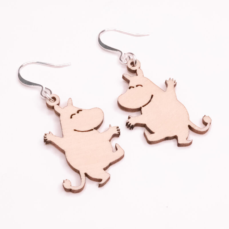 Die Coruu Moomin Wooden Earrings von Coruu sind Ohrringe aus Holz im nordischen Stil in Form eines lächelnden Cartoon-Nilpferds mit erhobenen Armen. Sie haben Metallhaken und sind auf einem weißen Hintergrund abgebildet.