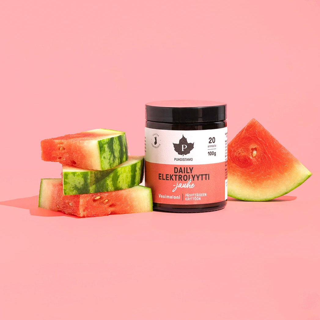 Eine Dose Puhdistamo Daily Electrolyte Powder Watermelon steht neben drei gestapelten Wassermelonenscheiben und einem großen Wassermelonenstück, die alle auf einem pastellrosa Hintergrund angeordnet sind.