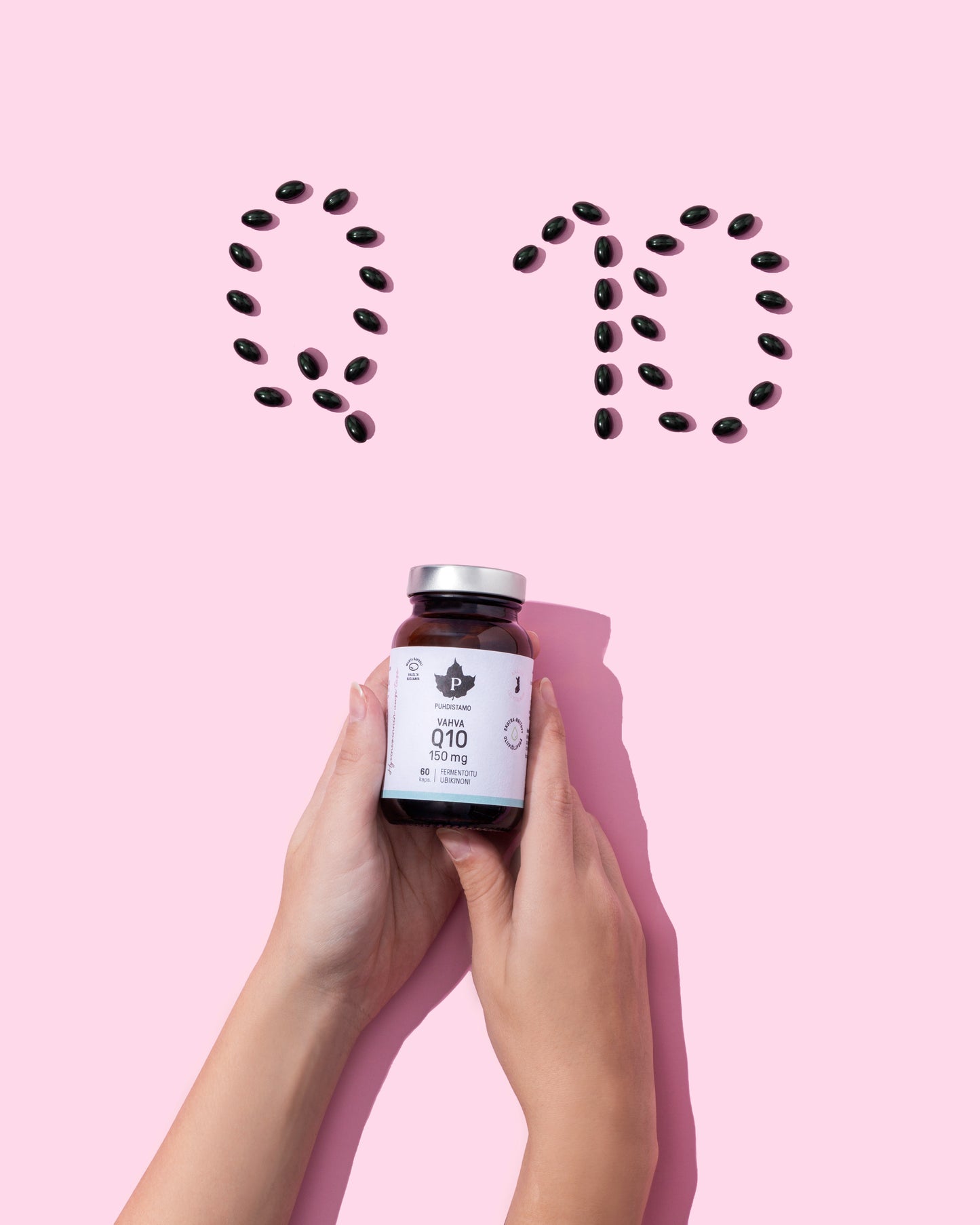 Zwei Hände halten ein Fläschchen Puhdistamo High-Strength Q10 Ubiquinone 150 mg; oben steht auf den schwarzen Kapseln in Rosa "Q10", was die Rolle von Puhdistamo bei der Unterstützung des Energiestoffwechsels durch dieses wirksame Ubiquinon-Ergänzungsmittel unterstreicht.