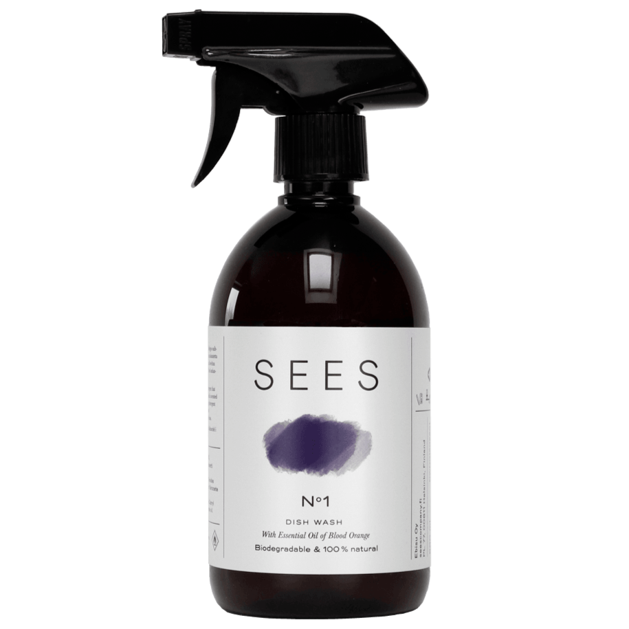 Eine braune Sprühflasche mit der Aufschrift SEES Dishwashing Liquid von SEES Company ist mit einem violetten Pinselstrich versehen und wirbt für die 100 % natürliche, biologisch abbaubare und umweltfreundliche Formel mit ätherischem Blutorangenöl.