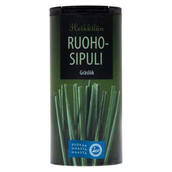 Ein zylindrischer Behälter mit der Aufschrift Heikkilä's Chives der Marke Heikkilä's zeigt auf der Vorderseite frischen Schnittlauch und beschreibt dessen milden Zwiebelgeschmack und kulinarische Vielseitigkeit.