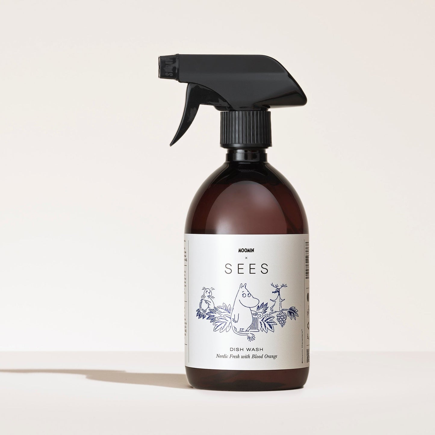 SEES Company Le spray vaisselle SEES Company x Moomin, présenté dans un flacon brun orné d'animaux et de plantes dessinés, est photographié sur un fond clair. Ce liquide vaisselle biodégradable permet un nettoyage respectueux de l'environnement.