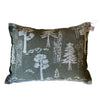 L'oreiller Metsä/Skogen Sauna Pillow de Metsä/Skogen est un oreiller rectangulaire vert foncé orné de contours blancs représentant des arbres, des montagnes et des paysages, et doté d'une petite étiquette en tissu dans le coin supérieur droit.