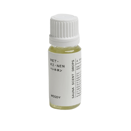 Une bouteille transparente avec un bouchon blanc contient Hetkinen Sauna Scent Woody, qui capture l'expérience du sauna finlandais. L'étiquette indique le nom du produit, la marque Hetkinen et la description en anglais et en japonais.