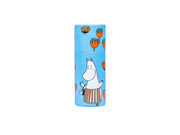 Il balsamo per le labbra Gustaf & Linnea Moomin Moominmamma è contenuto in un contenitore cilindrico blu con fiori arancioni e Moominmamma su uno sfondo a pois, ed è un balsamo per le labbra svedese ecologico e fatto a mano.