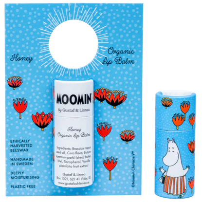 De Gustaf & Linnea Moomin Lipbalm Moominmamma is een milieuvriendelijke balsem met honingsmaak in een blauwe verpakking met rode bloemen en een Moomin-personage, gemaakt van ethisch verantwoorde bijenwas en verpakt in een plasticvrije verpakking.