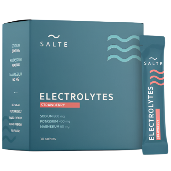 Een blauwgroene doos SALTE Electrolytes Strawberry met een zakje ernaast. Dit veganistische, suikervrije hydratatiepoeder bevat natrium, kalium en magnesium, heeft een aardbeiensmaak en bevat 30 zakjes. Merk: SALTE.